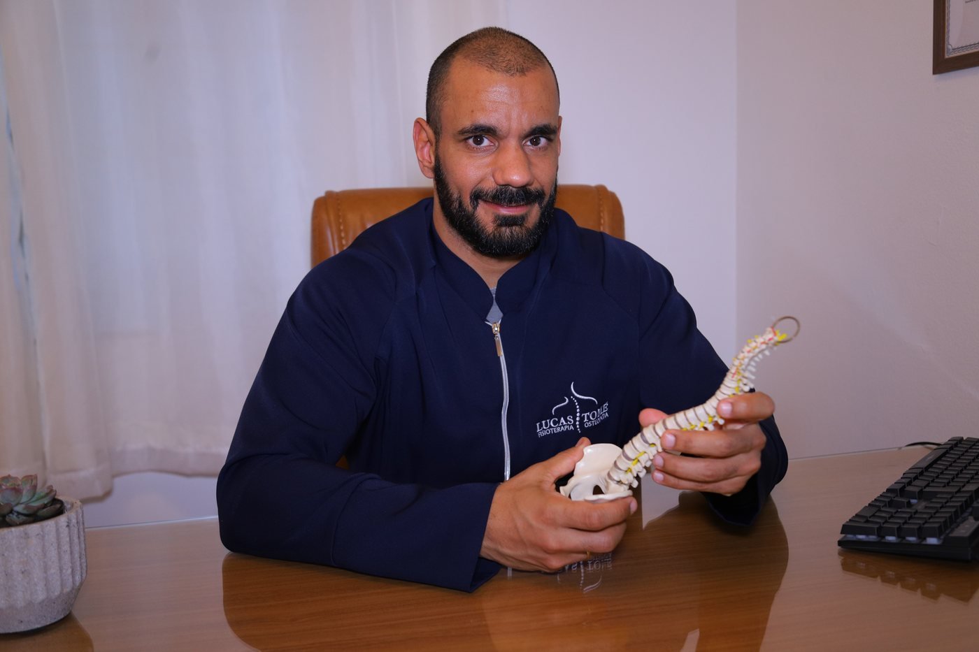 Lucas Tomé explicando a mecânica da coluna com modelo anatômico